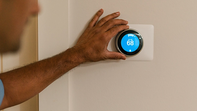 An asv technician holding a thermostat.