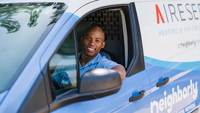 Technician smiling in a van.