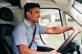 Smiling Aire Serv tech driving van.