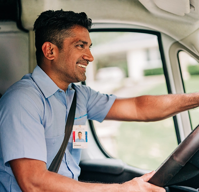 Aire Serv smiling while driving an Aire Serv van.