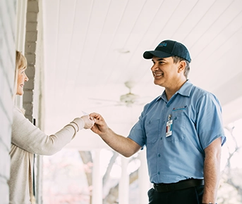 Female customer greeting ASV repairman at the front door.