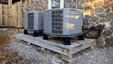 Outdoor dual zone heat pumps next to house.