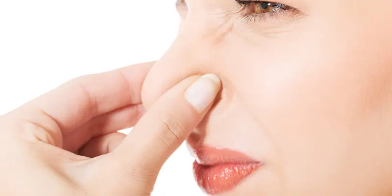 Woman holding nose